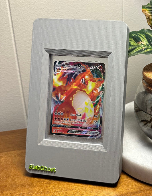 Framed collectible card on a table next to a plant