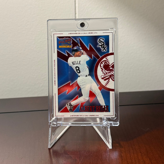 Baseball trading card of Albert Belle in a clear one touch holder suspended with a cheap acrylic plastic stand on a wooden surface with a neutral background