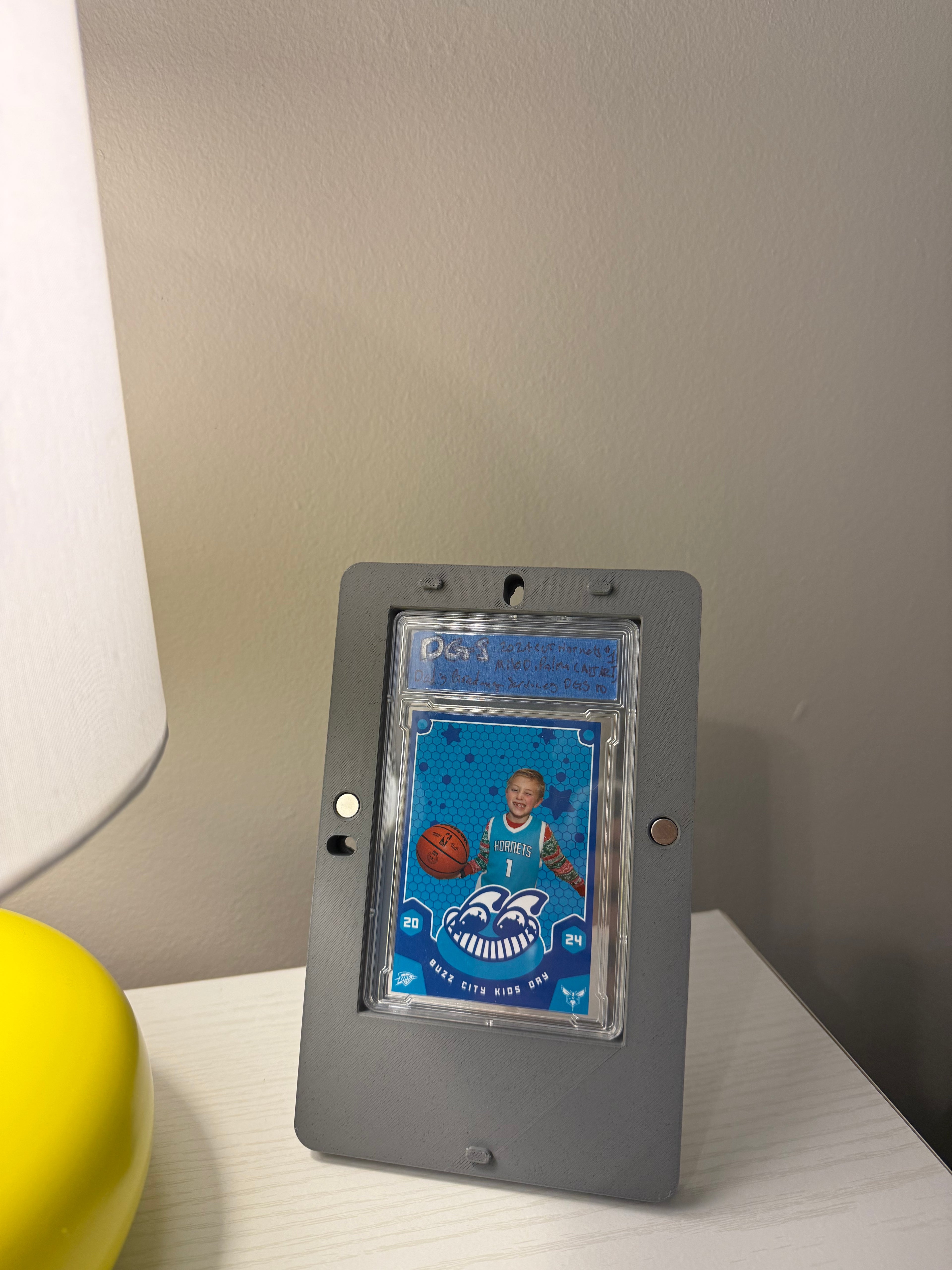 Framed collectible card on a table next to a lamp